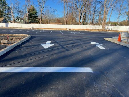 view of the entrance to the new parking lot with enter and exit arrows painted